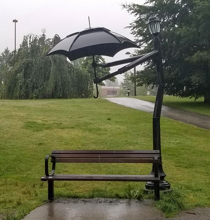 Latarnia trzymająca parasolkę nad ławką